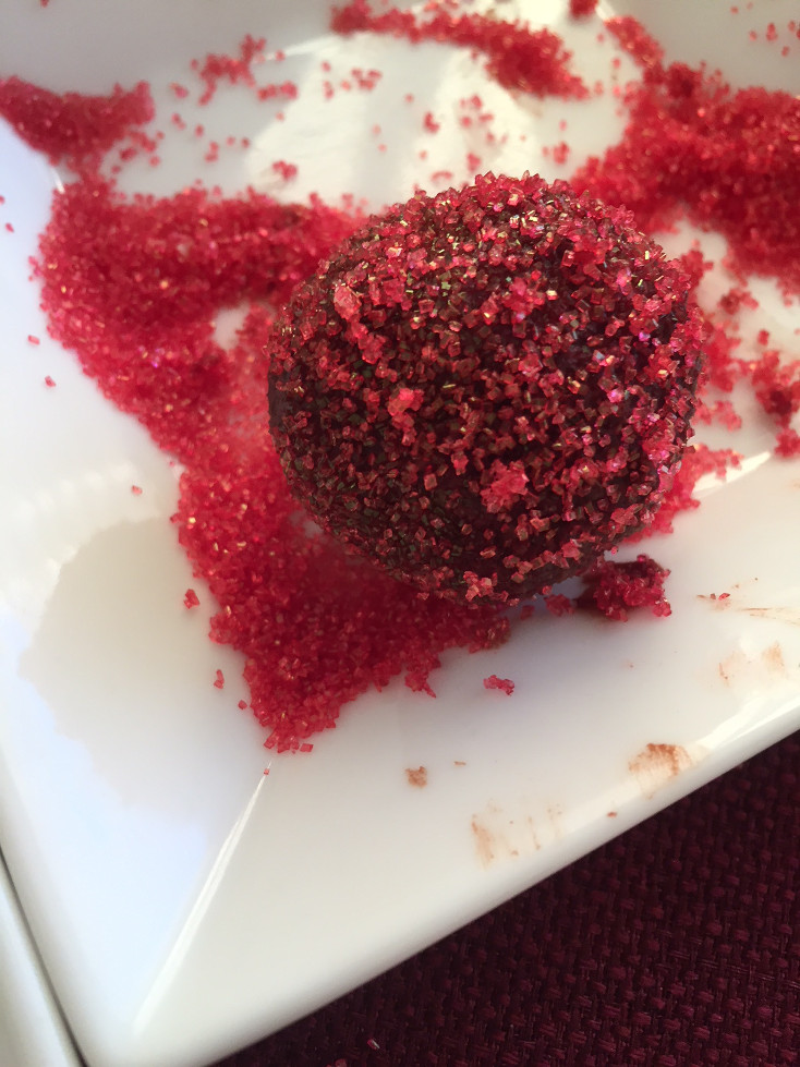 rolling the first chocolate truffle in red sugar sprinkles for an easy chocolate truffle recipe Valentine's Day dessert ideas Those Someday Goals