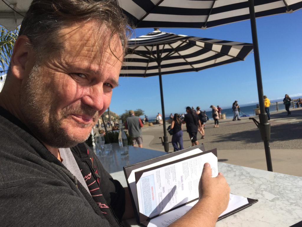 Andy under the umbrellas at Blue Moon Over Avila in Avila Beach, California Those Someday Goals