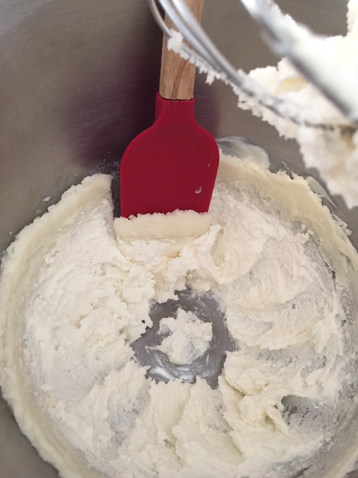 Creamed butter/sugar in a stand mixing bowl with a red mixing spoon Banana Chocolate Chip Muffins Recipe Baking Those Someday Goals