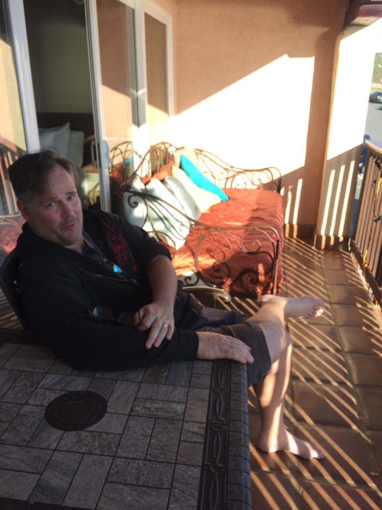 Andy enjoying the view next to the iron day bed on the balcony at Inn at Avila Beach Avila Beach hotel Those Someday Goals