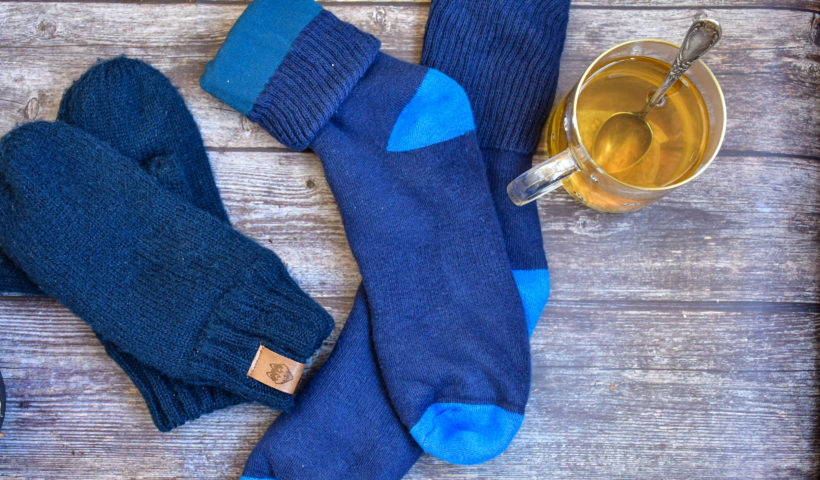 Blue Socks Blue Glovers on Wood Table by glass mug Shutterstock Decluttering Tips Those Someday Goals