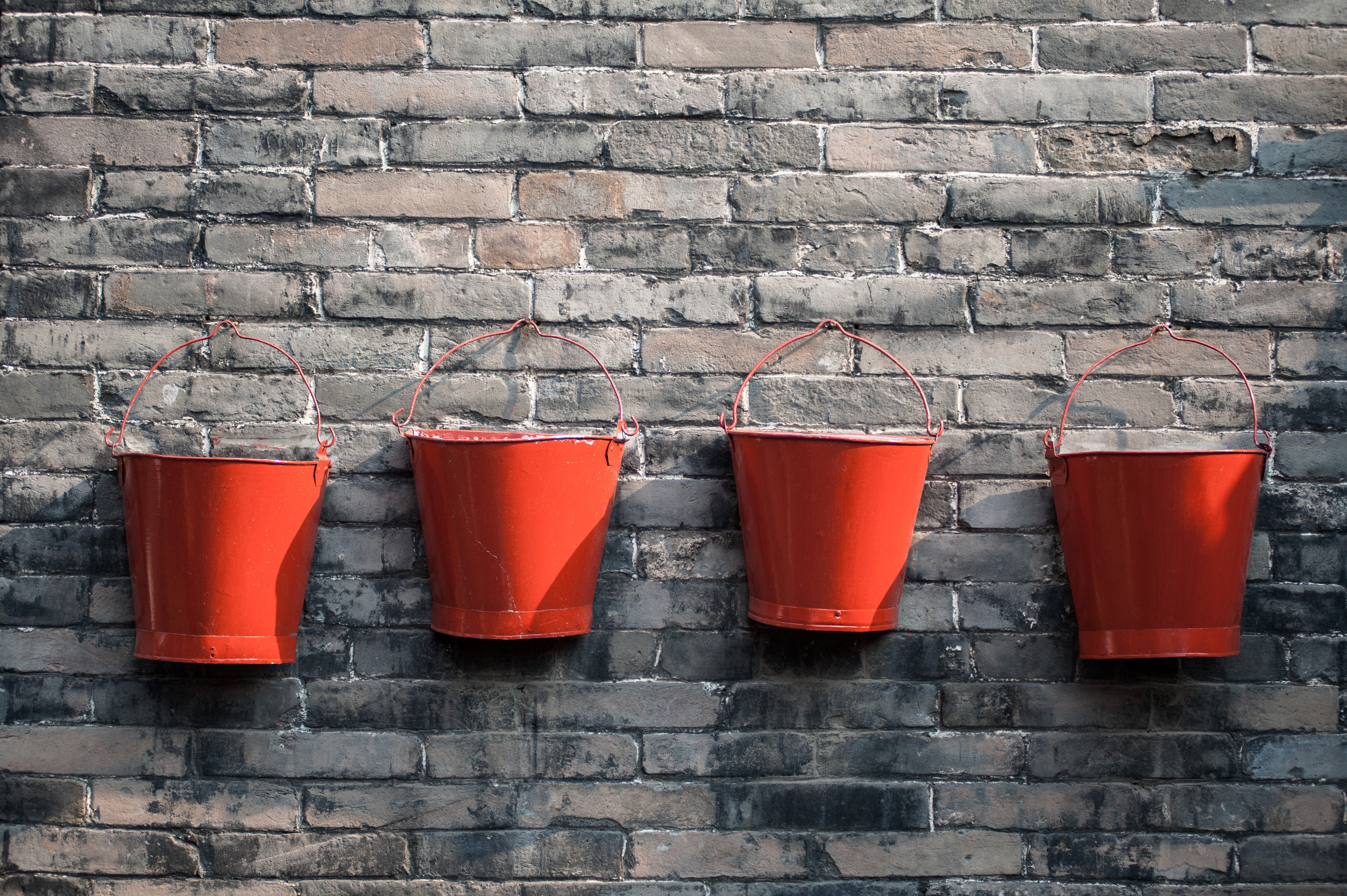 four orange red buckets on a brick wall time management bucket method productivity tips Those Someday Goals
