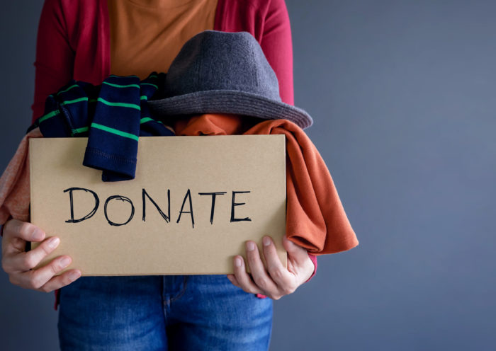 how to donate used clothes Declutter before the holidays Woman Holding Donate Box Shutterstock Black Salmon Those Someday Goals