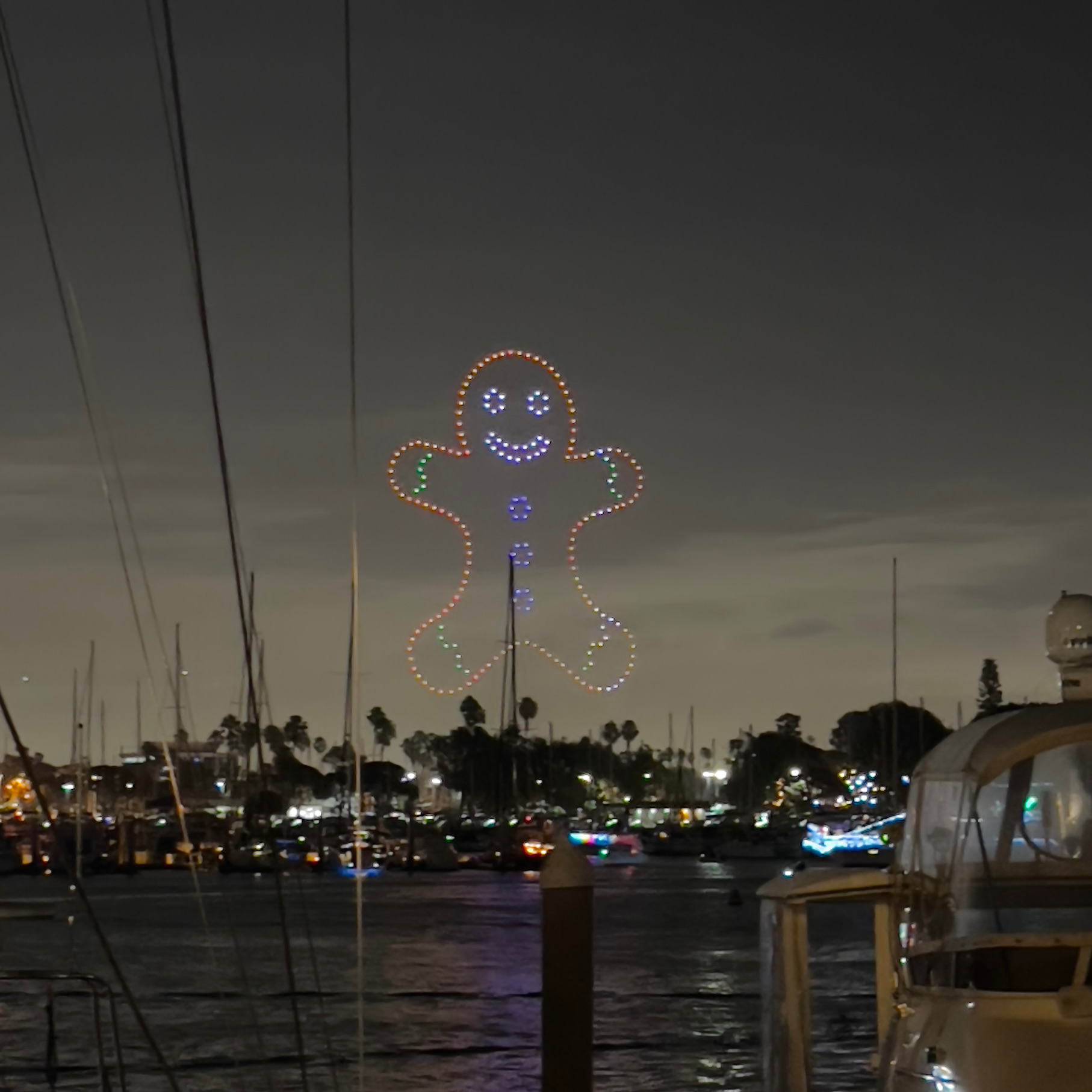 gingerbread drone lights over marina boat parade holiday lights Christmas decorations
