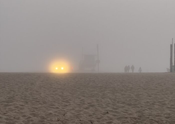 Beach in Fog headlights winter lifeguard shack people walking on sand decluttering emergency kits