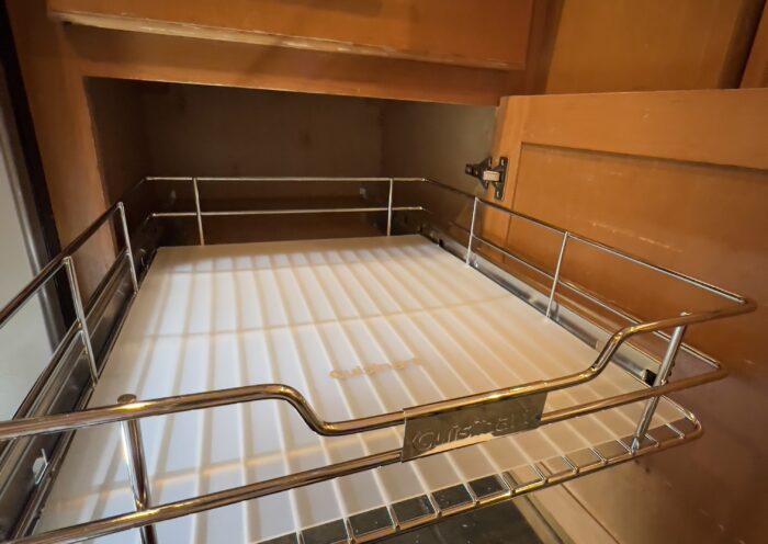 Sliding cabinet organizer is in place with steel basket and mat for easy and cheap kitchen remodel idea Those Someday Goals