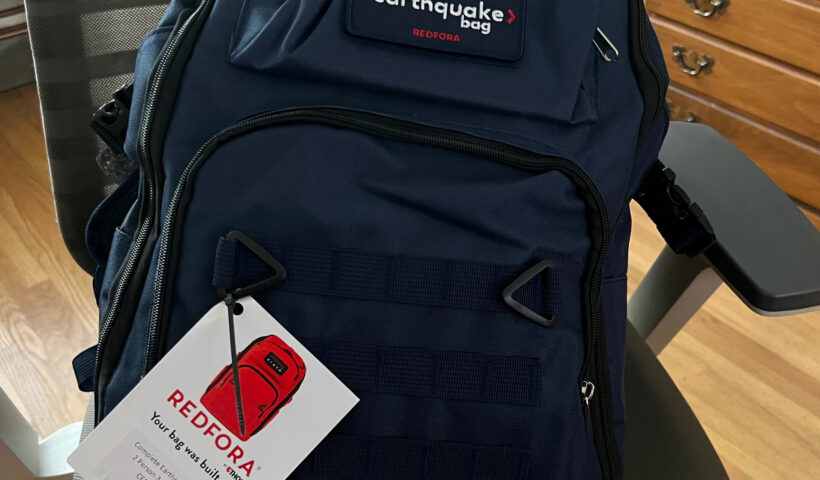 Redfora's Earthquake Bag in blue sitting on a desk chair over a wood floor near a cabinet
